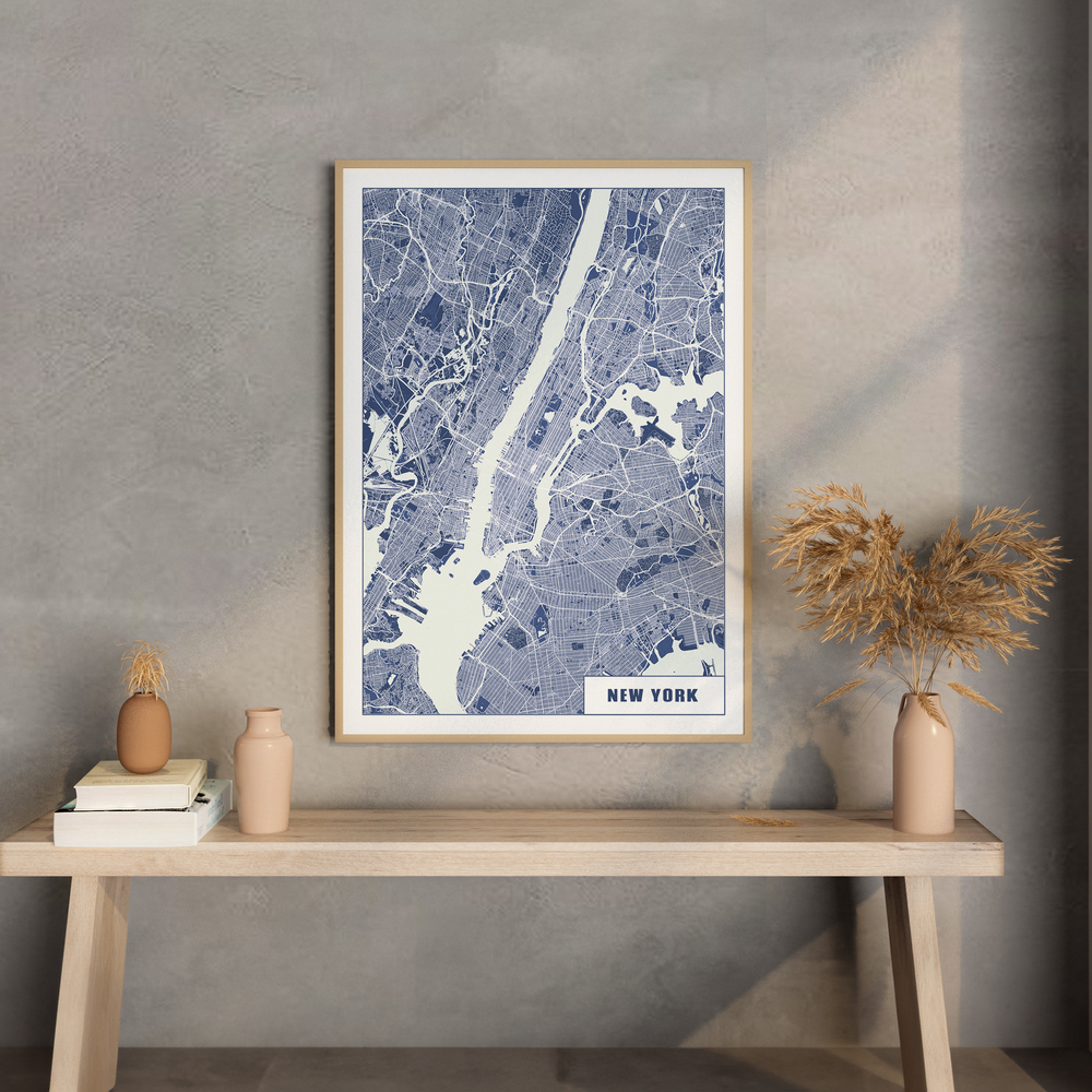 Lámina del mapa de Nueva York en azul y blanco, con marco de madera clara sobre una consola con jarrones