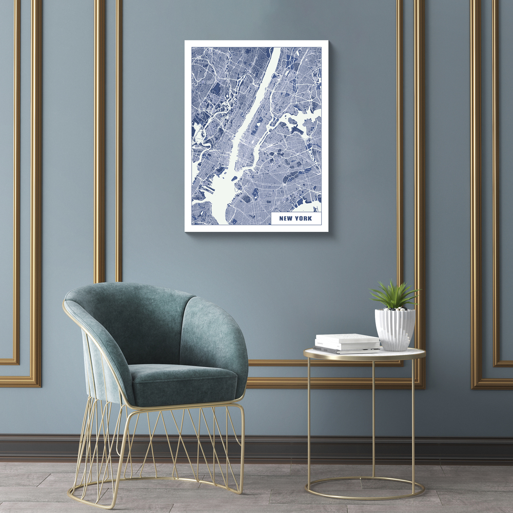 Póster del mapa de Nueva York en azul y blanco sobre un sillón, en una pared gris azulada con molduras doradas